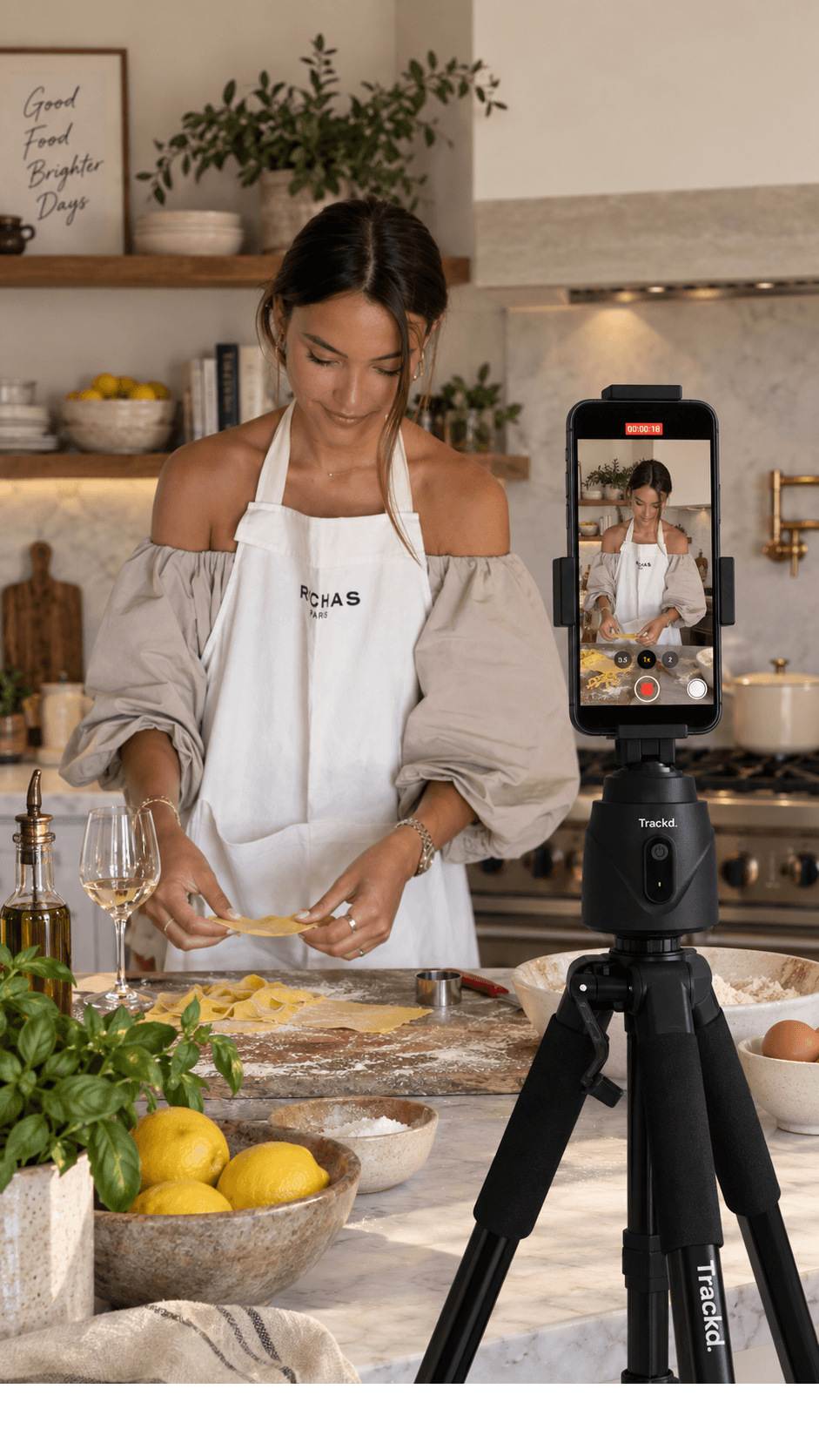 A creator making pasta in a kitchen with an iPhone on a Trackd Mount in the foreground