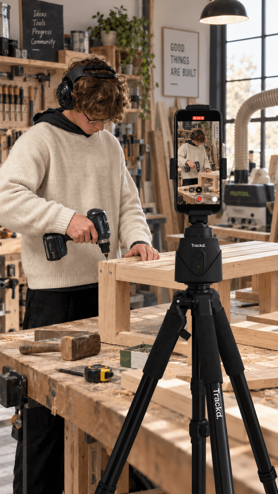 A maker building a wooden project at a workbench with an iPhone on a Trackd Mount in the foreground