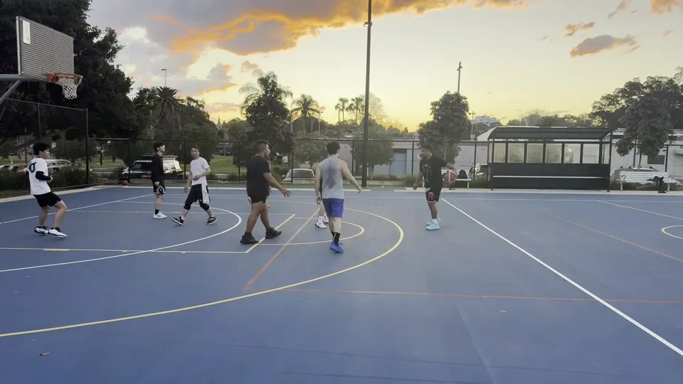 Trackd filming a basketball game on an outdoor blue court